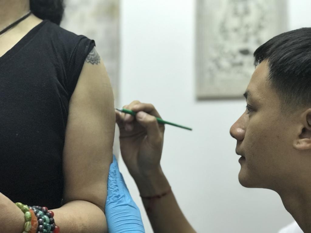 Thai monk performing a sak yant tattoo